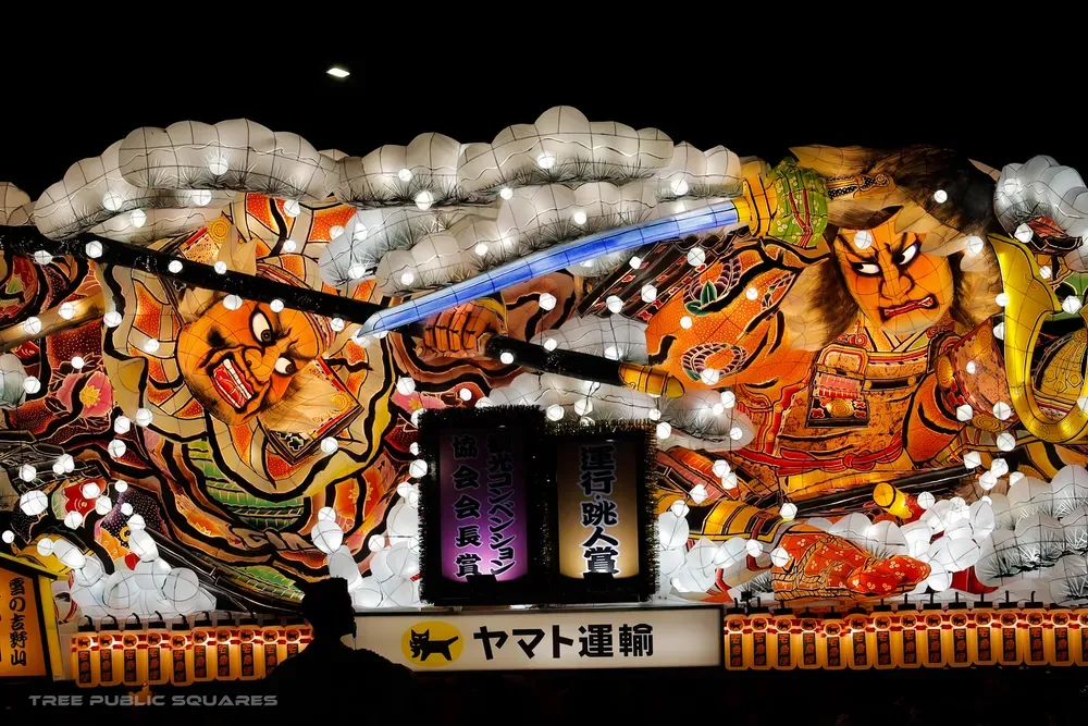 Warrior Nebuta float glowing from within, washi paper over wire